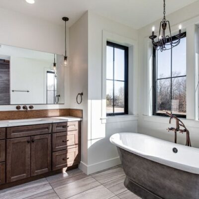 Rustic Meets Contemporary Style Bathroom Renovation - Golden Rule Builders - Bathroom remodel / renovation, large bathtub with a chandelier above, next to windows overlooking a beautiful view and receiving lots of natural light, and a large variety