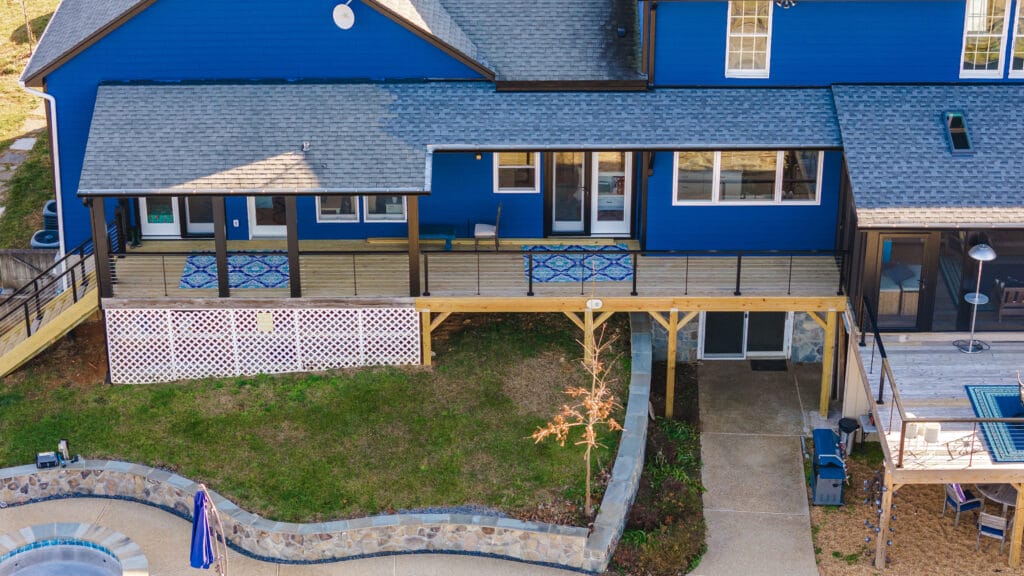 Whole House Remodel in Hume, VA - Golden Rule Builders - Whole house remodel, Drone shot of the beautiful blue houses backyard with two different decks, a covered patio and a hot tub