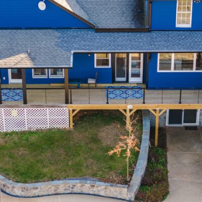 Whole House Remodel in Hume, VA - Golden Rule Builders - Whole house remodel, Drone shot of the beautiful blue houses backyard with two different decks, a covered patio and a hot tub